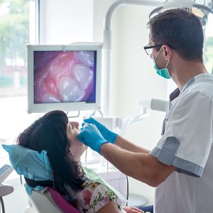 Dentist Examining Patient Teeth With Intraoral Camera